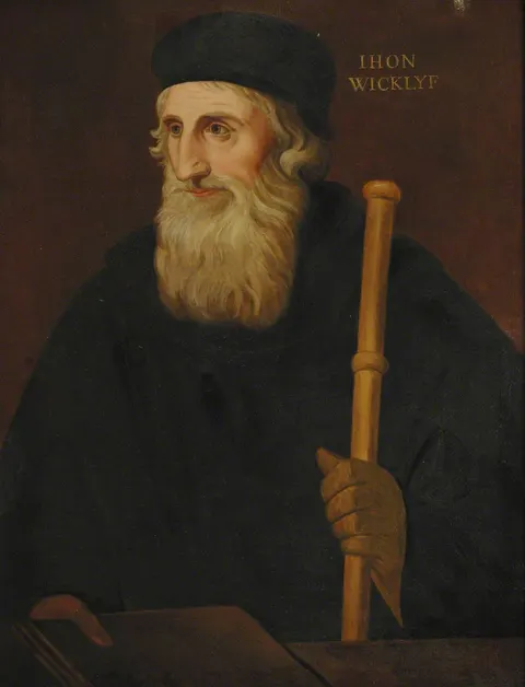 Portrait of John Wycliffe in a dark cap and gown, holding a staff, with a book beneath his hand